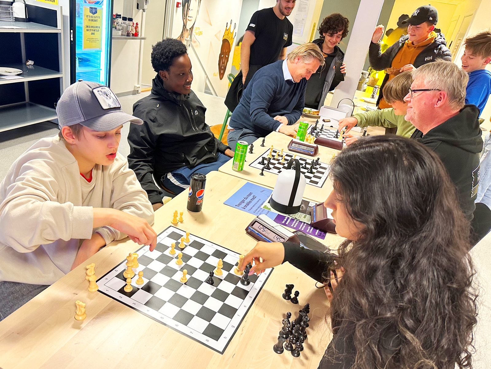 Sjakkurs: Nils (14) spiller mot kursholder Ariza Hina (18) på Fellesverket i Bergen. Eks-sjakkpresident og daglig leder i Bergen Røde Kors, Morten L. Madsen, spiller i bakgrunnen.