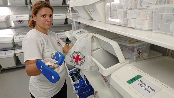 Alexa fra Kypros Røde Kors viser frem sko som deles ut til flyktninger. 