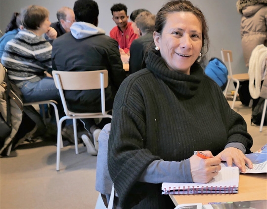 En kvinne på norsktrening ser i kamera. 