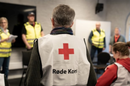 mann med røde kors vest