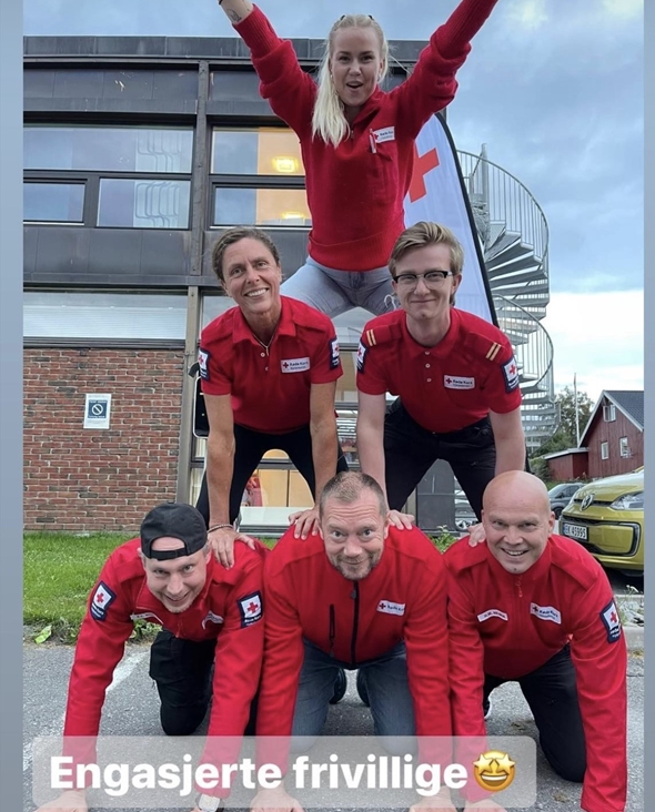 Frivillige med står i pyramide oppe på hverandre.