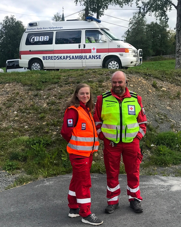 Frivillige foran en beredskapsambulanse