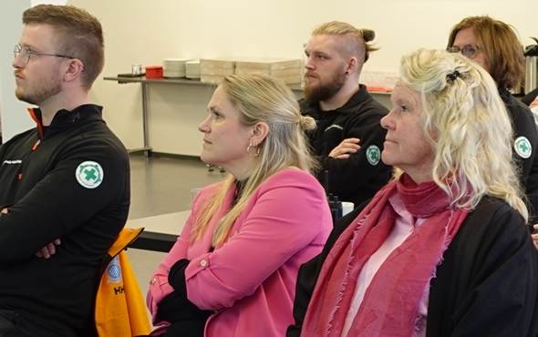 Foto av rygger med Røde Kors-logo i forsamling