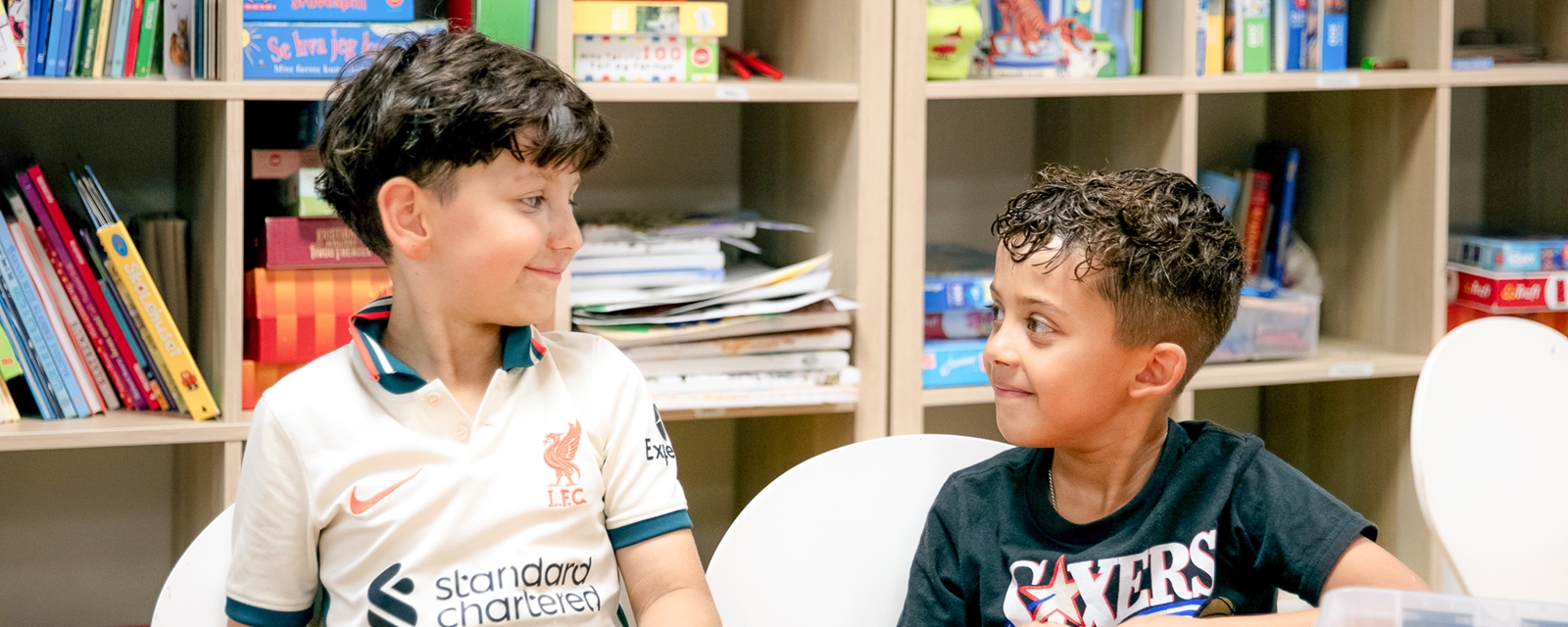 To gutter som smiler og ser på hverandre