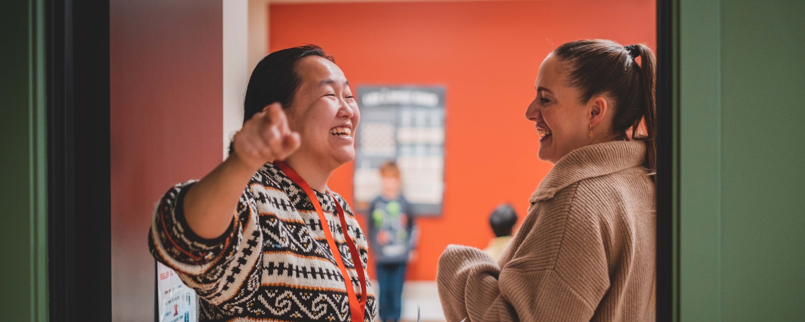 To damer fra Oslo Røde Kors i samtale mens de smiler