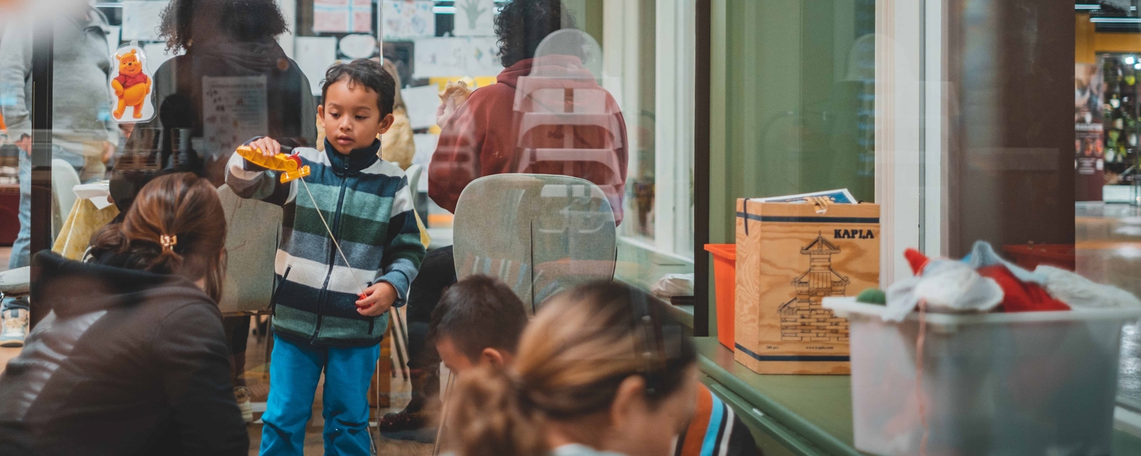 Gutt som leker på på Røde Kors sitt familiesenter.