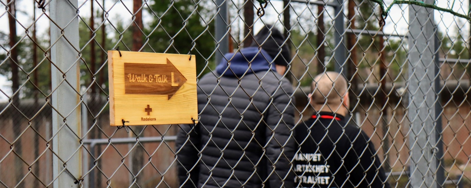 to personer bak et gjerde