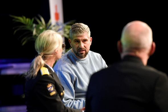 Tre personer snakker sammen på en scene.