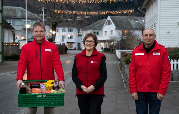 Tre Røde Korsarar deler ut matkasser