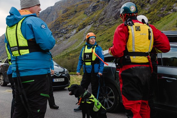 Redningspersonell og hund kledd i redningsvest