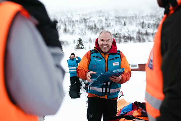 Smilande mann i blå vest forklarar korleis ein skal bruke varmeteppe