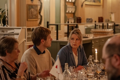 Kvinne ved bord ser undrande ut