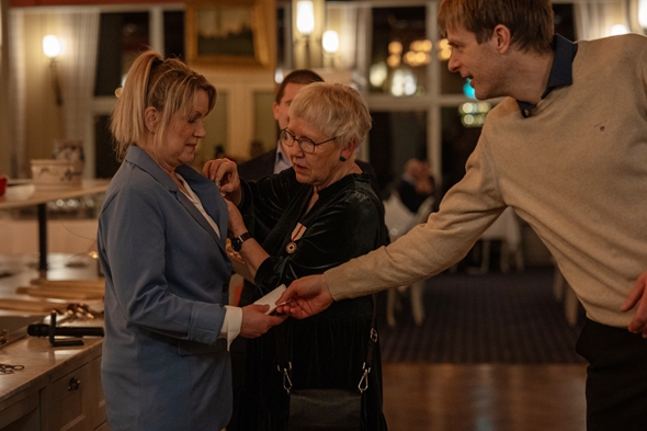 Kvinne mottek pris, mann gjev lommetørkle