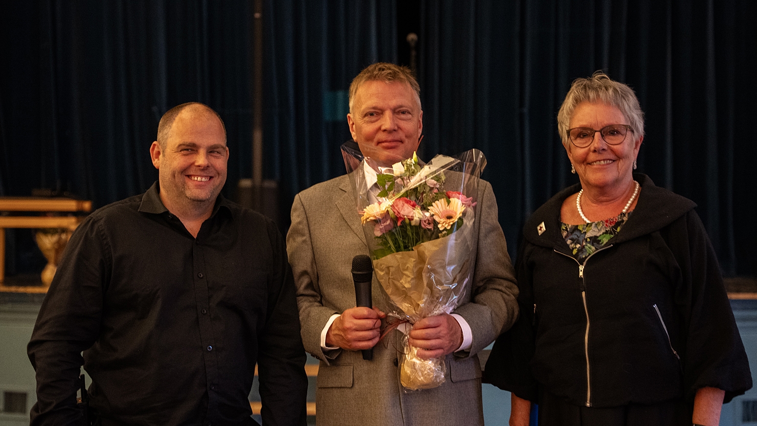 Ei kvinne, to menn, ein blomsterbukket