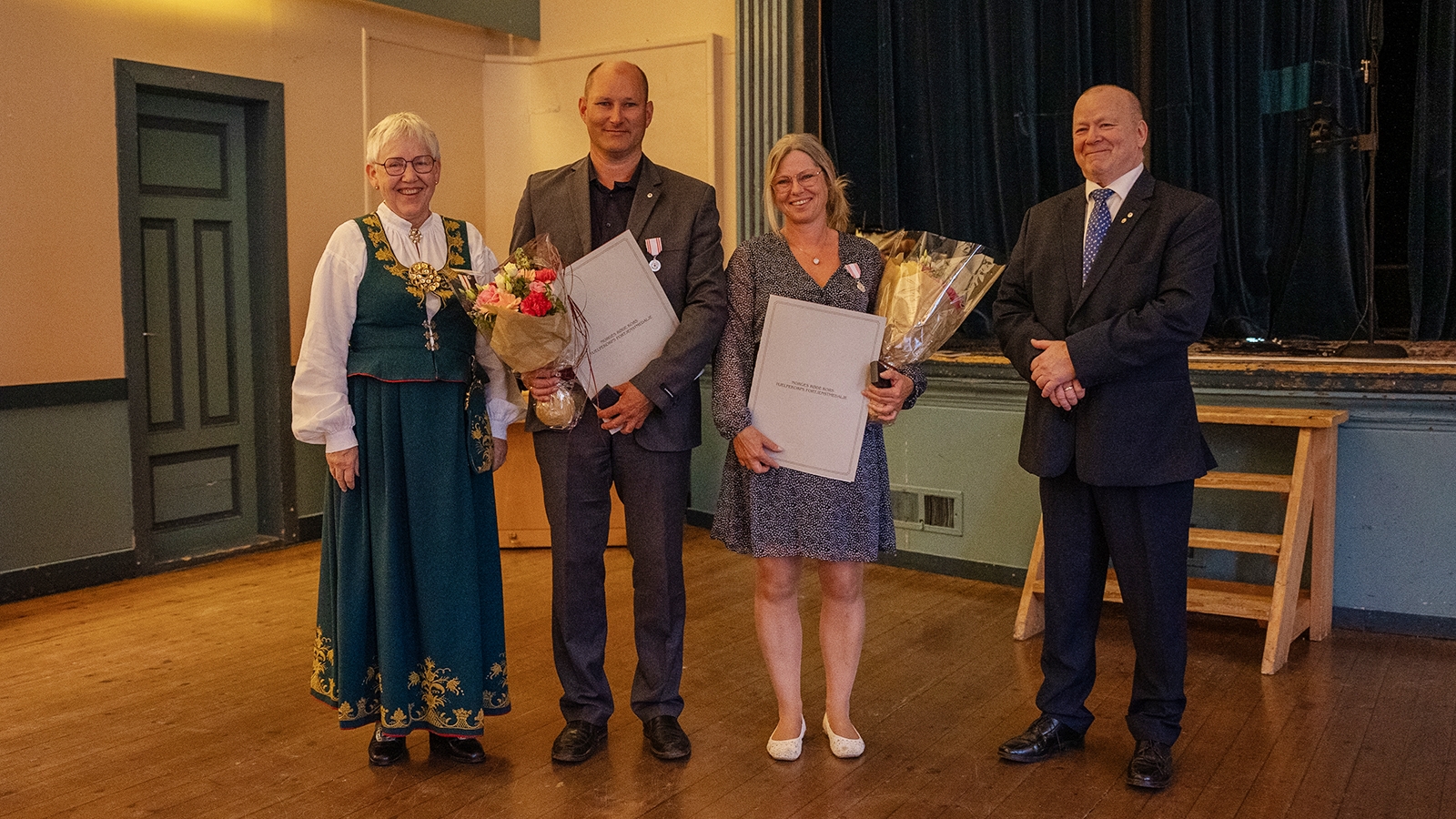 Festkledde mottakarar av heisersmedalje og diplom