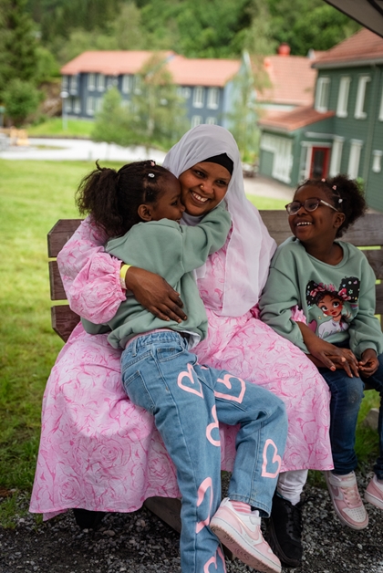 Mor med to jenter som er likt kledd