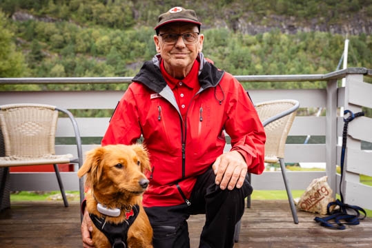 Arne Helge Seljen smiler med hunden Luna ved sida si.