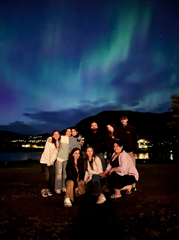 Ein gjeng georgiske ungdommar smilar under nordlyset