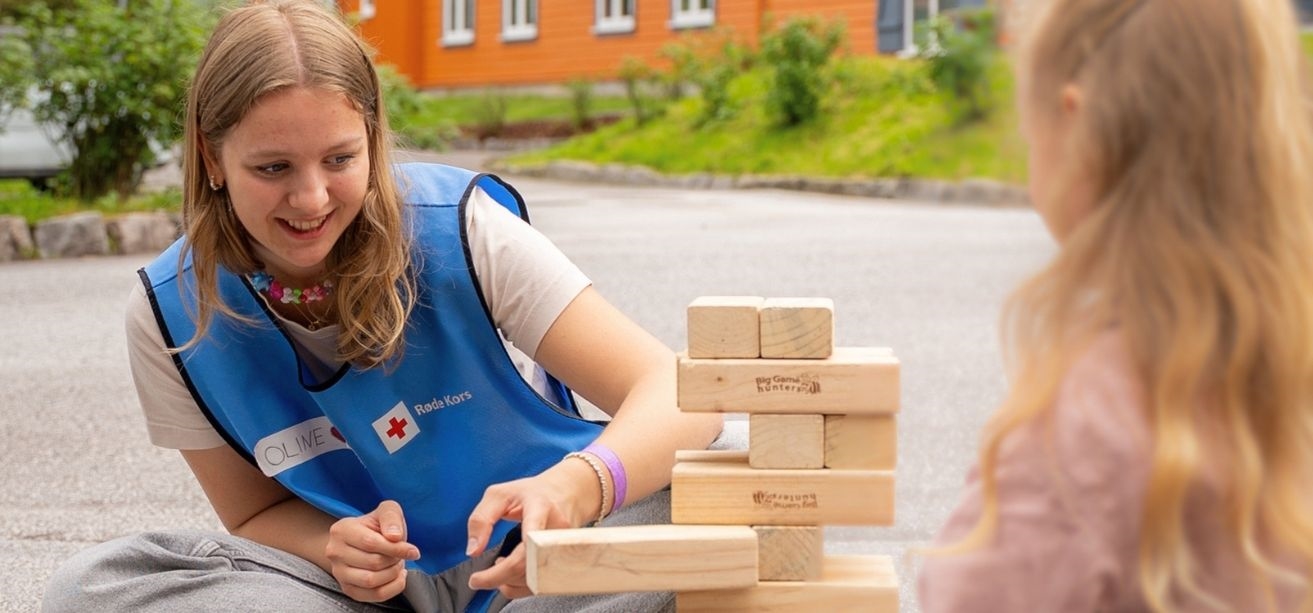 Oline spelar spel ilag med ei lita jente.