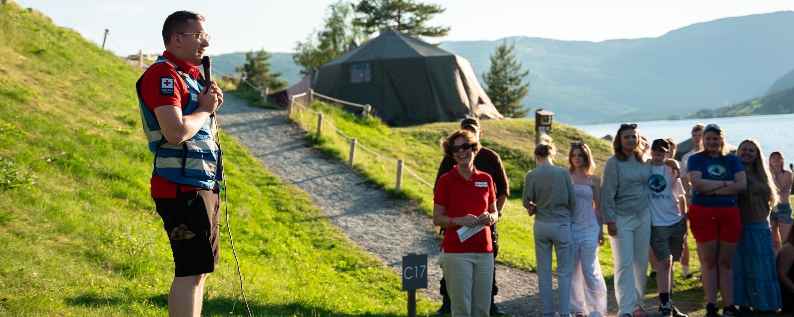 Jon Atle pratar i mikrofon under nasjonal Røff-camp i 2024. Til høgre for han står president Siri Hatlen.