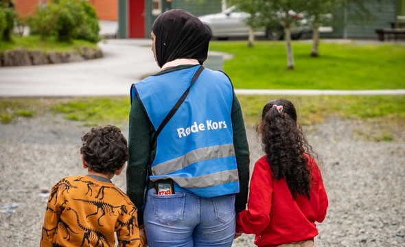 Bildet viser Hiba som held to barn i hendene.