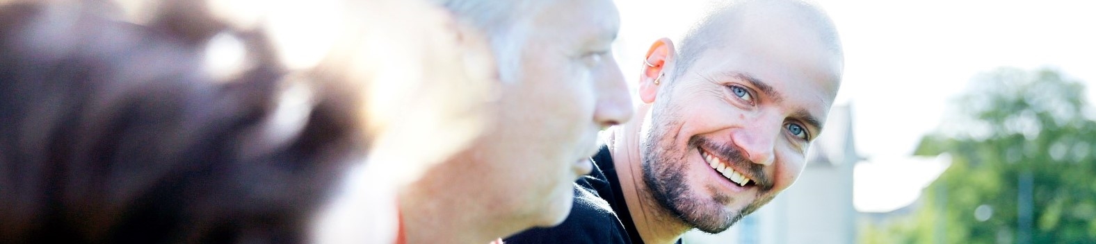 Mann ser i kamera smiler