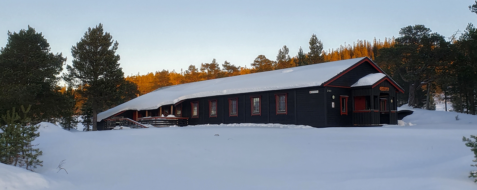 Hytte i snødekt landskap.