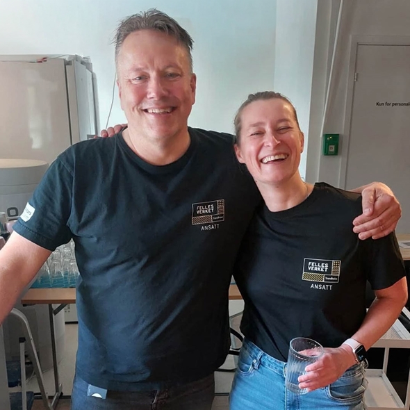 Senterleder på Fellesverket Ander Näsström og Mira Tkacz som jobber på kjøkkenet smiler til kamera.