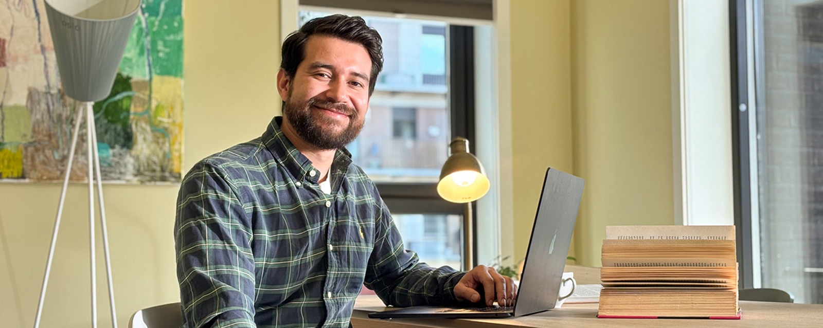 Frivillig sitter ved PC og smiler.