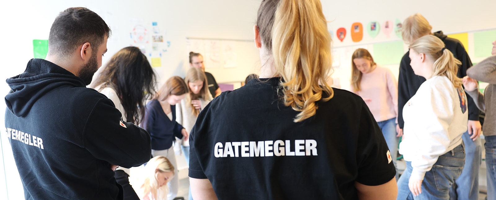 En gruppe står samlet på gulvet under workshop med Gatemegling.