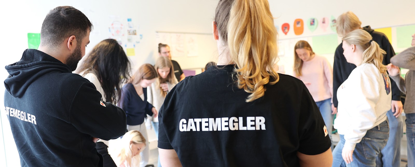 En gruppe står samlet på gulvet under workshop med Gatemegling.