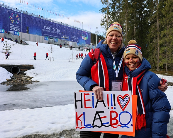To glade supportere med "HeiaKlæbo" skilt utenfor Granåsen stadion.