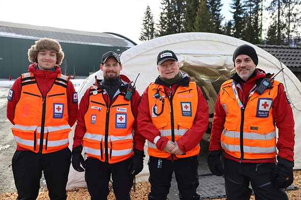 Frivillige hjelpekorpsene poserer foran Røde Kors-teltet under Ski-VM i Granåsen.