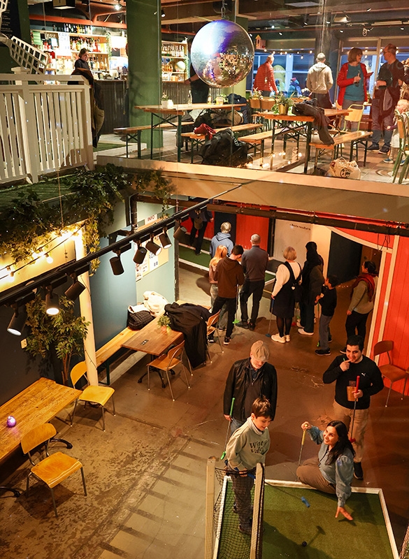 Flere som mingler og spiller minigolf inne på Trondheim Camping