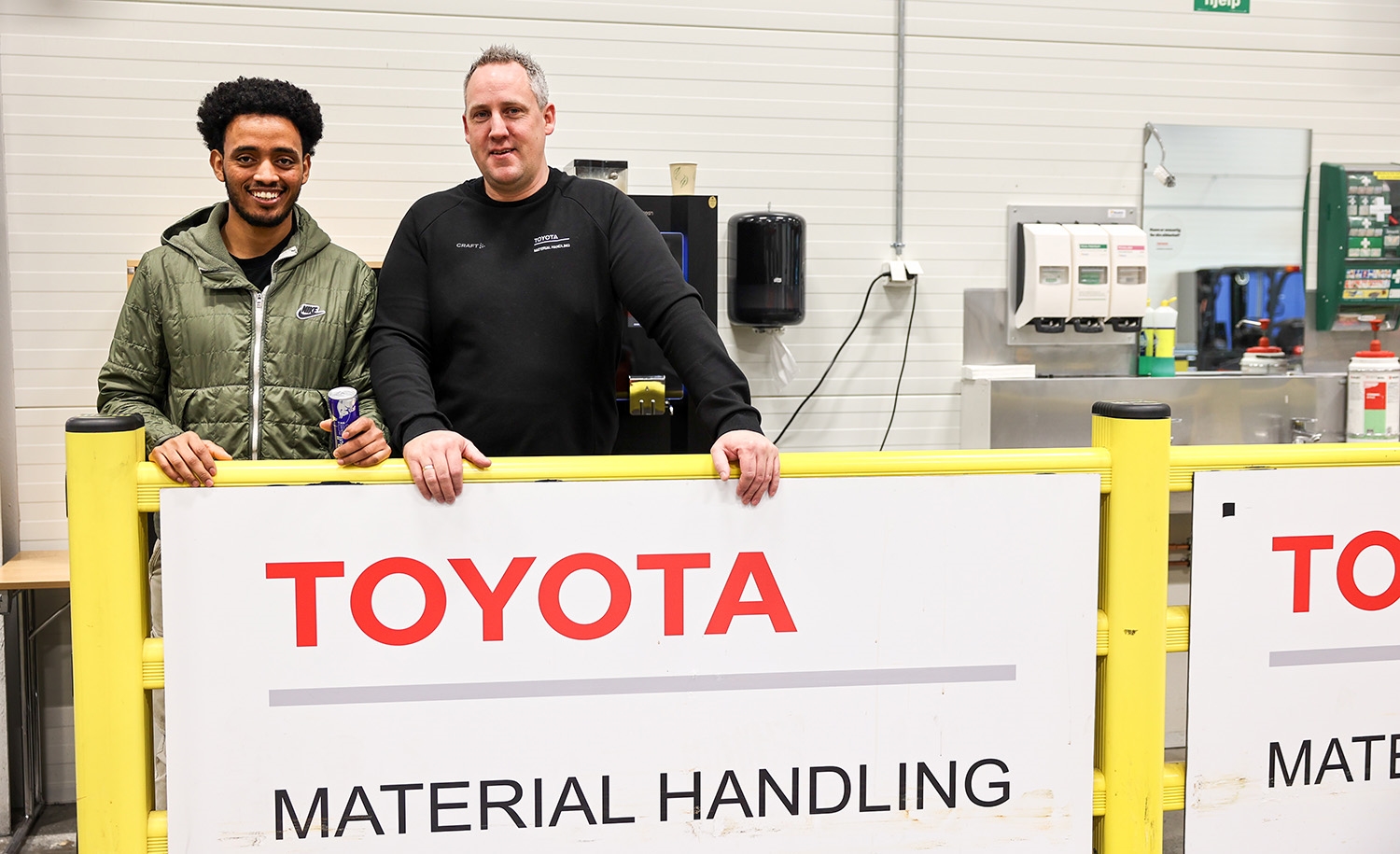 Abel M. Beyene og kursinstruktør Ola Melby sammen foran Toyota Material Handling skilt 