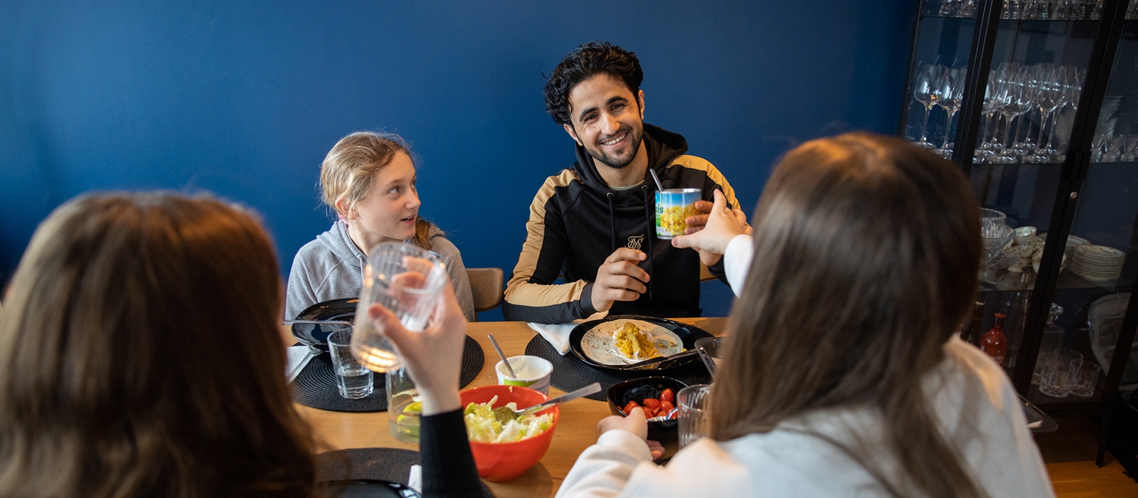 Vennefamilie spiser middag sammen.