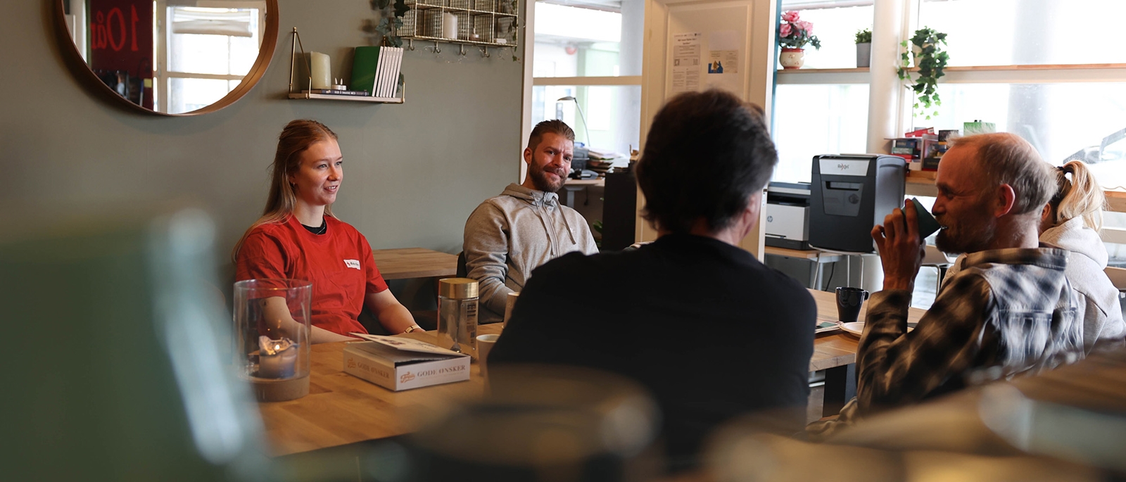 Flere sitter samlet rundt bordet på "Folk" møteplassen til Nettverk etter soning.