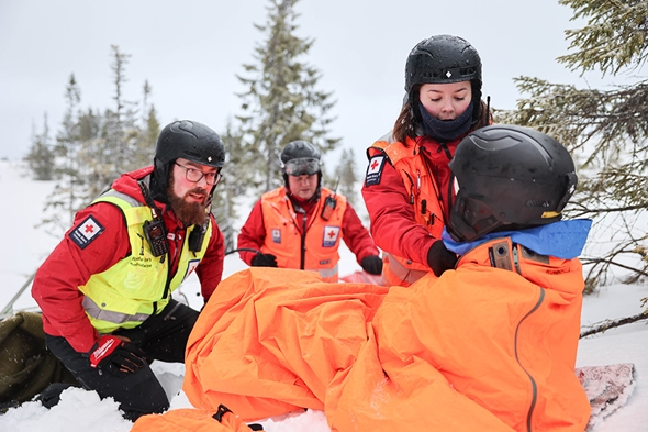 Tre frivillige fra hjelpekorpset demonstrerer et fiktivt henteoppdrag i bymarka.