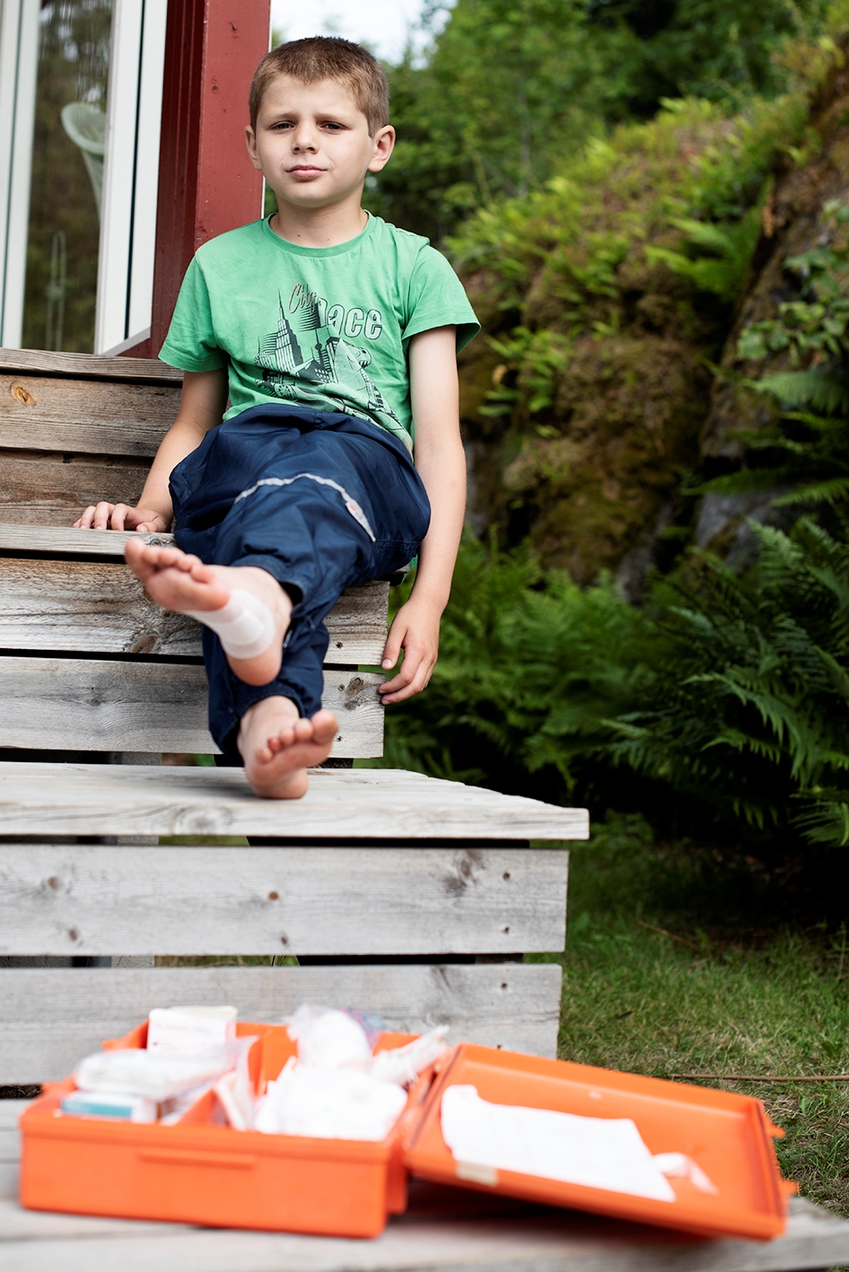 Bilde av en plastret fot med teksten: Plaster, kompress, gasbind, sårvask-servietter, øyeskylle-væske, pinsett,  saks og brannbandasje bør alltid finnes i førstehjelpsskrinet ditt.