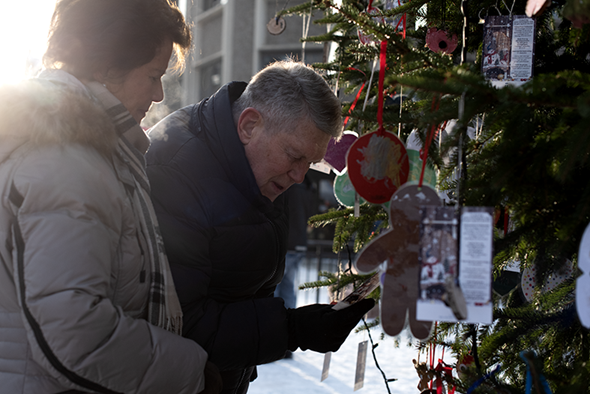 Et ektepar ser på ønskelapper på et juletre