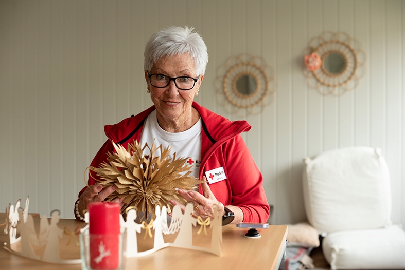 En dame sitter og lager julestjerne i tre