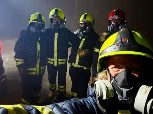 selfie av fem frivillige i brannuniform og med hjelmer. Ser ikke ansiktene ordentlig.