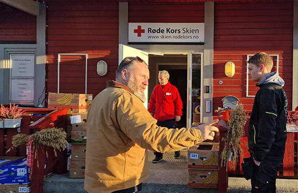 En mann legger en eske inn i en bil