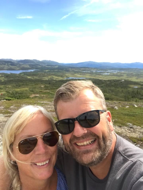 Selvportrett av en mann og en dame på tur i fjellet om sommeren.