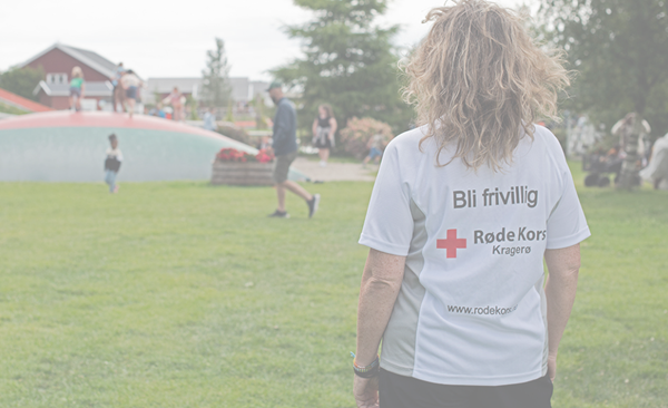 Kvinne står med ryggen til, tekst på t-skjorte: Bli frivillig og med logo Røde Kors. Barn leker i bakgrunnen på trampoline
