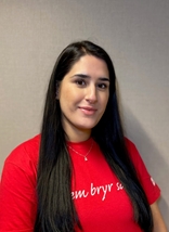 Zalla har på seg en rød skjorte med Røde Kors-logo. Hun smiler til kamera.