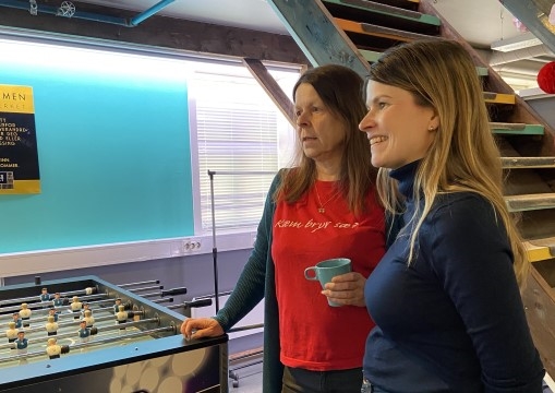 To kvinner i samtale ved et fotballspill.