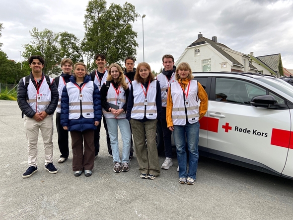 Bildet viser ni feltselgere som smiler til kamera.