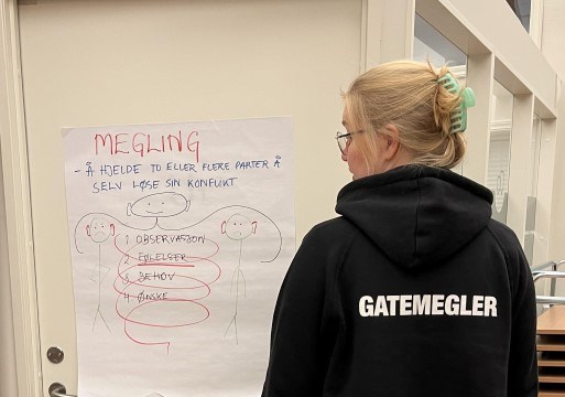 En frivillig gatemegler står foran en forsamling og holder kurs om konflikthåndtering.