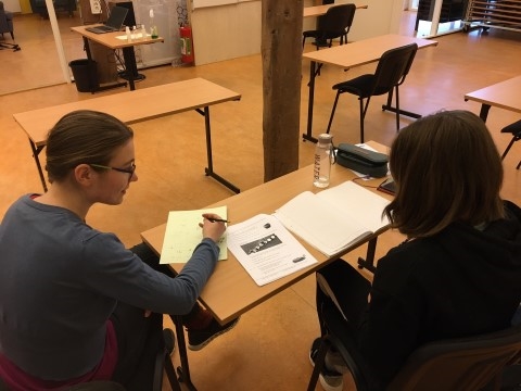 Bildet viser en leksehjelper som hjelper en ungdom med mattelekser.